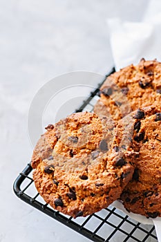 Homemade chocolate chips cookies on a wire rack on a white stone