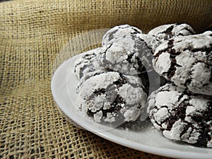 Homemade chocolate cookies. Chocolate brownie cookies in powdered sugar in burlap background. Selective focus