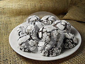 Homemade chocolate cookies. Chocolate brownie cookies in powdered sugar in burlap background. Selective focus