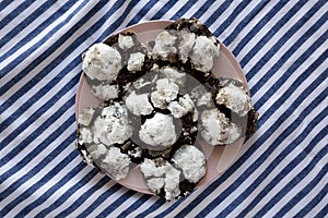 Homemade Chocolate Crinkle Cookies on a pink plate, top view. Flat lay, overhead, from above