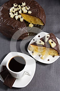 Homemade chocolate-glazed pineapple cake and a cup of coffee with three pieces of chocolate