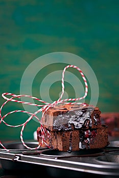 Homemade chocolate sweet brownies cakes with cherry and chocolate sauce or syrup on a dark background