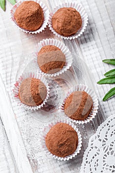 Homemade Chocolate truffles candy dessert on wooden background close up. Delicious chocolate praline with decor