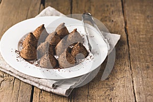 Homemade Chocolate Truffles With Cocoa Powder on a White Plate Old Wooden Background Tasty Candy Copy Space