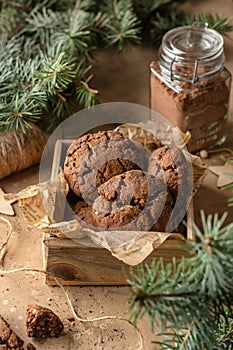 Homemade christmas chocolate cookies in wooden box on brown festive background with fir tree branches. Christmas holiday