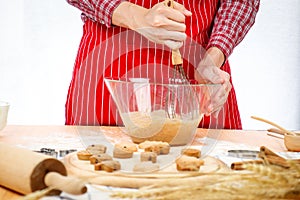 Homemade Christmas cookies, bakery man preparing gingerbread cookies dough, mixing ingredient together in the bowl by using whisk