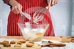 Homemade Christmas cookies, bakery man preparing gingerbread cookies dough, mixing ingredient together in the bowl by using whisk