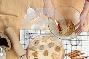 Homemade Christmas cookies on wooden tray, bakery man preparing gingerbread cookies dough, mixing ingredient together in the bowl