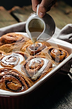 Homemade Cinnamon roll pastry with white cream sauce. sweet traditional dessert buns