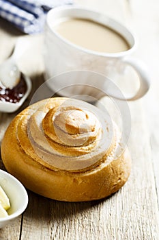 Homemade cinnamon roll served with butter and jam