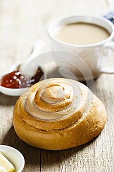 Homemade cinnamon roll served with butter and jam