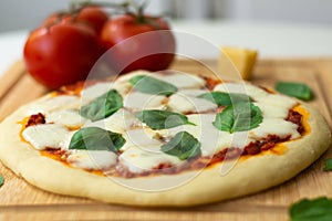 Homemade classic italian napoli pizza with tomato sauce, mozzarella cheese and basil leaves: pizza napoletana.