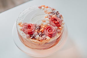 Homemade Classic Vanilla Marble Cream Cake Sprinkled with Creamy Flowers Decorations on a White Plate