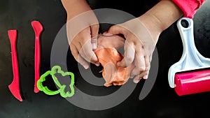 Homemade clay. Child hands playing with colorful clay. Homemade plastiline.