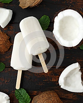 Homemade coconut popsicles, ice lolly, on wooden table. Summer food.