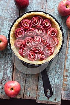 Homemade comfort food. Raw apple rose pie in cast iron pan with