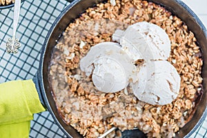 Homemade cooked rhubarb and apple crumble with oatmeal and vanilla ice cream