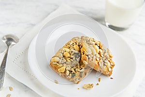 Homemade cookies with cereals and nuts with milk on a marble table.