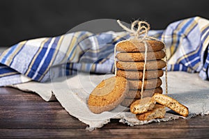 Homemade cookies with chocolate, nuts and coffee beans on a light wooden background with a linen napkin with a background blur.