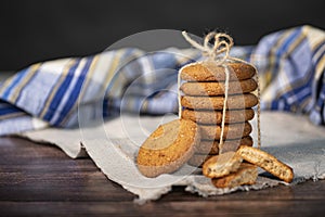 Homemade cookies with chocolate, nuts and coffee beans on a light wooden background with a linen napkin with a background blur.