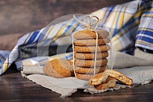 Homemade cookies with chocolate, nuts and coffee beans on a light wooden background with a linen napkin with a background blur.