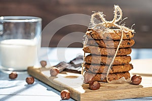 Homemade cookies with chocolate, nuts and milk on a wooden table and an art phone in the morning. Close up. Breakfast.