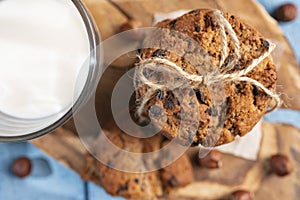 Homemade cookies with chocolate, nuts and milk on a wooden table and an art phone in the morning. Close up. Breakfast.