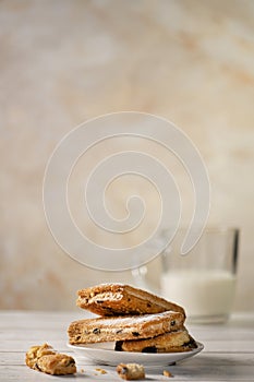 Homemade cookies with chocolate, nuts, raisins, milk on a wooden background. Breakfast.