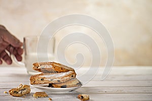 Homemade cookies with chocolate, nuts, raisins, milk on a wooden background. Breakfast.