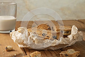 Homemade cookies with chocolate, nuts, raisins, milk on a wooden background. Breakfast.