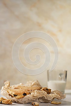 Homemade cookies with chocolate, nuts, raisins, milk on a wooden background. Breakfast.