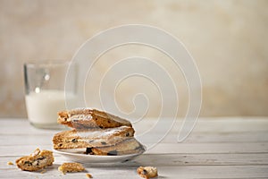 Homemade cookies with chocolate, nuts, raisins, milk on a wooden background. Breakfast.