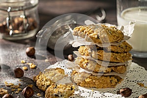 Homemade cookies with chocolate, nuts, raisins, milk on a wooden background. Breakfast.