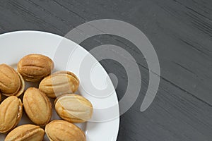 Homemade cookies with condenced milk on a white plate in a corner photo