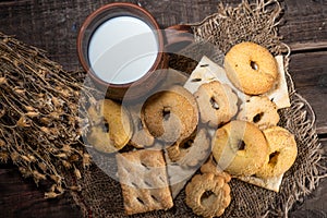Homemade cookies with a cup of milk on a rural wooden background