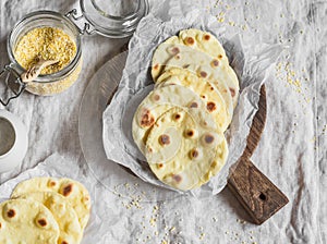 Homemade corn tortilla on a wooden rustic cutting board.