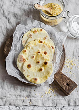 Homemade corn tortilla on a wooden rustic cutting board. On a light background