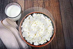 Homemade cottage cheese in a bowl on wooden table.