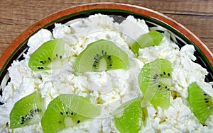 Homemade cottage cheese in a bowl on wooden table.