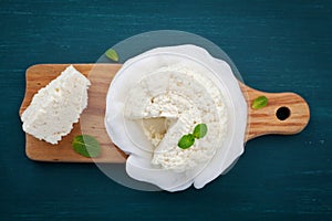 Homemade cottage cheese or curd on wooden board, rustic style