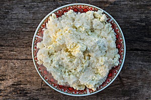 Homemade cottage cheese on old wooden table