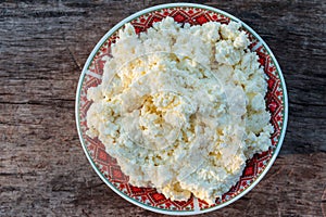 Homemade cottage cheese on old wooden table