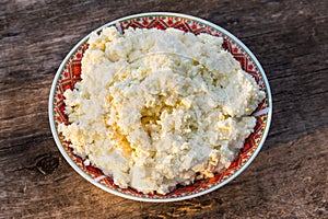 Homemade cottage cheese on old wooden table