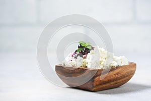 Homemade cottage cheese in a wooden bowl, diet concept.