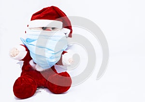 Homemade cotton Santa Claus play with a Covid-19 or Coronavirus protection mask photo