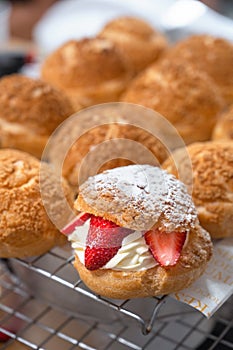 Homemade Craquelin Choux biscuits crispy cream puffs with cream filling and Strawberries on rack photo