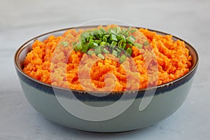 Homemade Creamy Mashed Sweet Potatoes with MIlk and Butter in a Bowl on a gray background, side view. Close-up