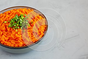 Homemade Creamy Mashed Sweet Potatoes with MIlk and Butter in a Bowl on a gray background, side view. Copy space