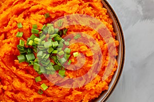 Homemade Creamy Mashed Sweet Potatoes with MIlk and Butter in a Bowl on a gray background, top view