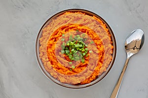 Homemade Creamy Mashed Sweet Potatoes with MIlk and Butter in a Bowl on a gray background, top view